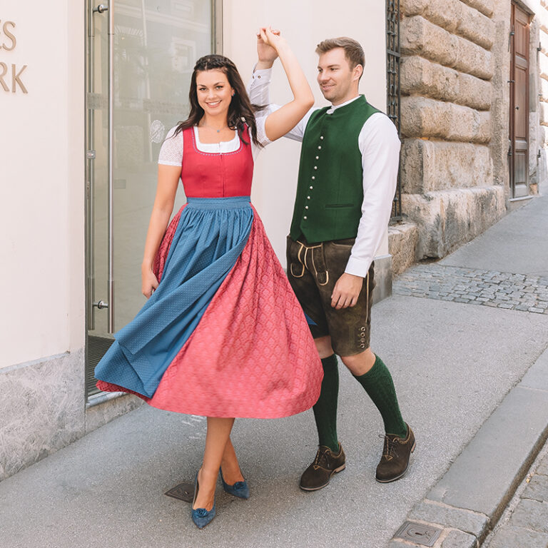 Tanzendes Paar in steirischer Tracht vor dem Steirischen Heimatwerk
